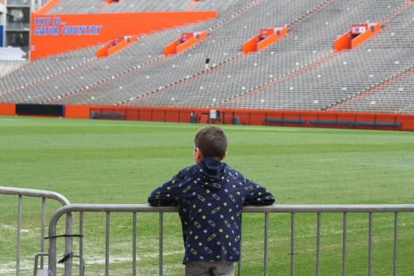 Jeune devant un stade de foot