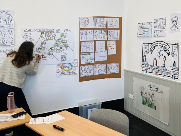 personne dessinant sur une feuille