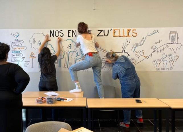 personnes accrochant des feuilles en papier sur un mur