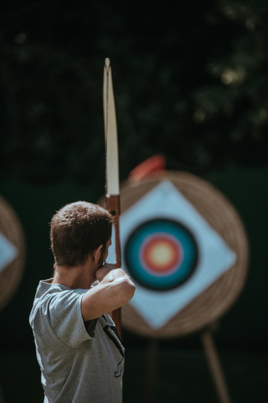 Jeune tirant dans une cible avec un arc à flèches